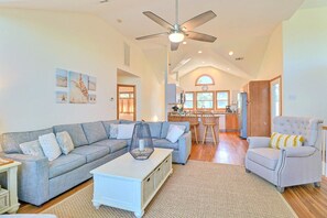 Blue Currituck Sound views abound from the bright and spacious top-level great room, with comfortable furnishings around the flat-screen TV.