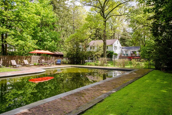 View from the gated pool towards the house with fabulous trees and landscaping 