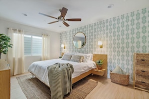 Soft, bright tones welcome you to the primary bedroom with minimalist boho accents and a king size bed.