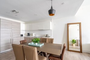 Espacioso comedor abierto conectado a una sala de estar luminosa con decoración moderna. Ideal para cenas acogedoras y momentos de relax con vistas espectaculares.