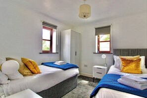 Stylish twin bedroom with luxurious bedding, ideal for working away from home or a long-term stay.