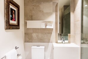A modern, sparkling clean bathroom featuring a refreshing shower, toilet, and soft, freshly laundered towels for your comfort.