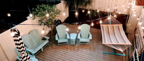 Beautiful string lighting over a hammock in the evening on our private patio