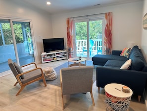 Large living room area with 50" smart TV, board games, books.
