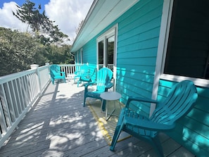 Large upper back deck nestled in trees.