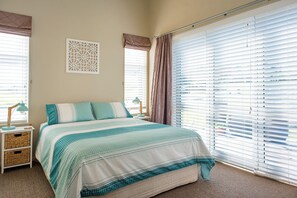 Master bedroom features Queen size bed and doors opening onto deck area