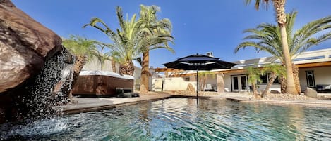 Crystal clear waterfall seat in the pool, hot tub, baja shelf with umbrella. 