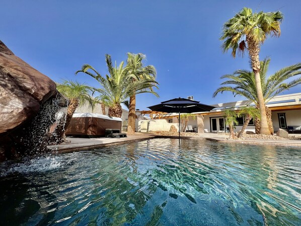 Crystal clear waterfall seat in the pool, hot tub, baja shelf with umbrella. 