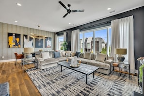 Open concept living area with designer furnishings and smart TV.