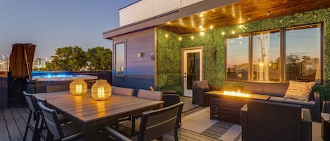 Private rooftop deck with outdoor fire pit, lounge area, dining area, BBQ grill, twinkling bistro lights, and HOT TUB.