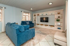 Open floor plan living area, fully air conditioned, books, smart tv