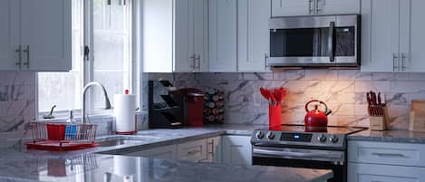 Enjoy preparing your meals in this modern kitchen featuring elegant marble.