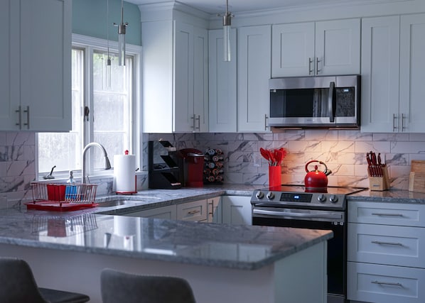 Enjoy preparing your meals in this modern kitchen featuring elegant marble.
