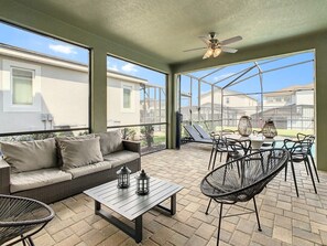 Relax in this spacious screened patio with pool views, perfect for outdoor dining and lounging.