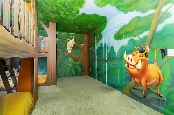 Immerse your kids in a jungle adventure with this enchanting treehouse-themed room, complete with playful murals and cozy bunk beds.