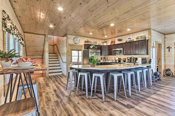 Make yourself at home inside 'Madison Bear Garden,' a 7-bed, 6-bath cabin! View the main-level kitchen from the front door