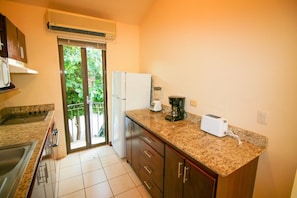 The galley kitchen comes equipped with all the dishes you need on vacation plus a small oven, cooktop, microwave, fridge and small appliances.