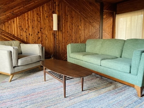 Comfy and welcoming living room with outdoor views and a warm wood stove 