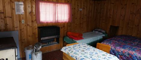 Cabin 5 is a cozy rustic cabin that features a wood-burning stove.