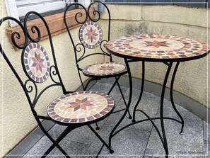 Mosaiktisch mit Stühlen auf dem Balkon 