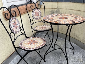 Mosaiktisch mit Stühlen auf dem Balkon