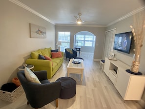 Living Room with smart TV, sleeper sofa and comfy pillows and throws.