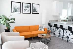 Open layout living room connected to kitchen with ample seating.