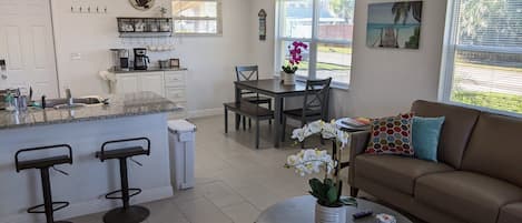 Open floor plan living room, kitchen and dining area with tons of light.