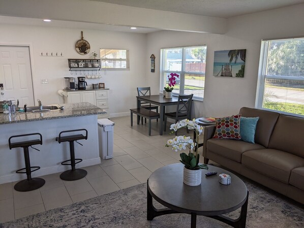 Open floor plan living room, kitchen and dining area with tons of light.