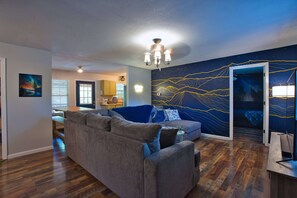 Beautiful mural with sectional pull-out couch 66-inch TV with surround sound