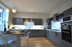 Spacious well equipped kitchen with integrated appliances and breakfast bar.
