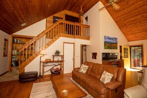 Aerial photo of open space living room, kitchen, dining room plus upstairs loft 