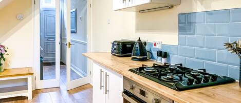 A fully equipped kitchen which includes a fridge and washing machine