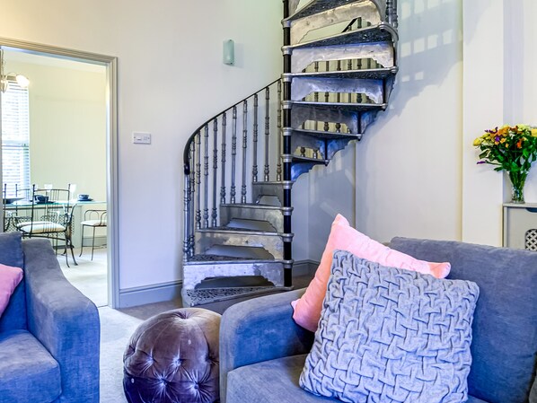 Living room featuring a quirky spiral staircase.