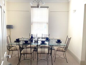 Spacious dining room with large dining table table and chairs. 