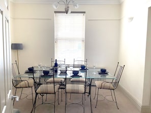Spacious dining room with large dining table table and chairs.