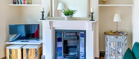 Living room, featuring a victorian fireplace and smart tv.