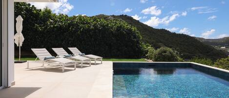 Extérieur : chaises longues - piscine - vue mer 