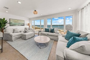 Step into this open-concept living room and den, where expansive windows offer stunning views of the water and beach. Relax in comfort while the beauty of the shoreline becomes your daily backdrop