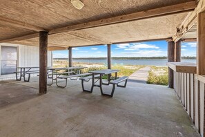 Gather under the raised beach house for the perfect shaded retreat! Enjoy picnic tables, BBQ amenities, and cool breezes—ideal for outdoor dining and relaxing away from the sun