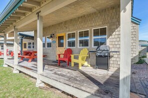Front porch with chairs, table and propane BBQ.