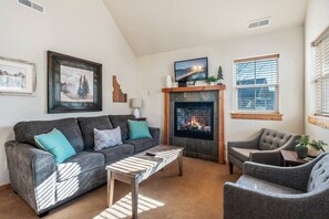 The spacious living area features a sofa sleeper, smart tv and gas fireplace.