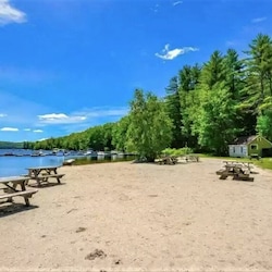 Large, sandy private beach on Moose Pond with picnic tables