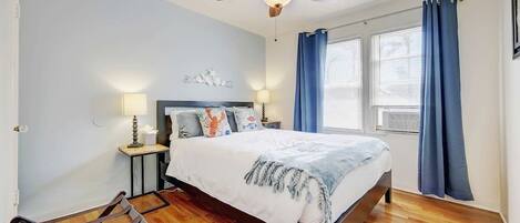 Brightly lit bedroom off the living room with a comfy queen size bed and plenty of space. 