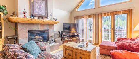 Cozy living area featuring a gas fire place, and picturesque windows offering mountain views.