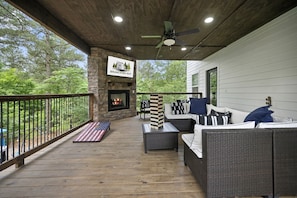 A 2nd story deck comes with comfortable seating, outdoor games, TV, and gas fireplace.