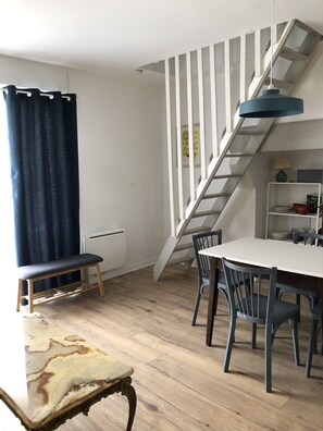 Vue sur salle à manger et escalier de meunier vers la mezzanine.