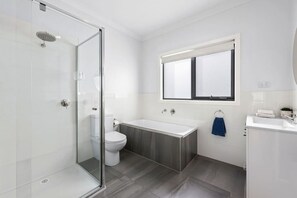 Modern bathroom with walk-in shower, toilet, and bath tub. Enjoy your bubble bath!