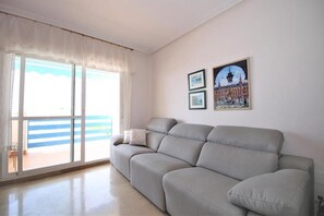 Comfortable sofa in the bright lounge with balcony access