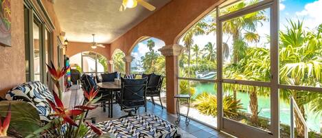 Unwind and relish the canal-front view from the screened porch at Casa Cudjoe.